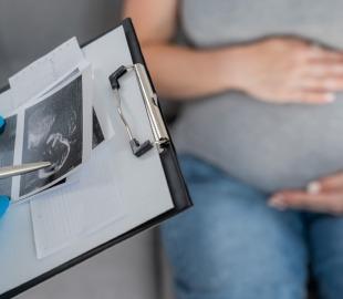 Médica analisa ultrassom enquanto gestante aguarda orientações sobre cada trimestre da gestação